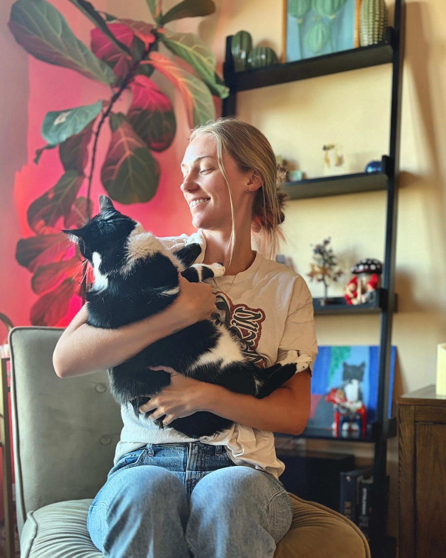 Hanna smiling while holding a black and white rescue cat