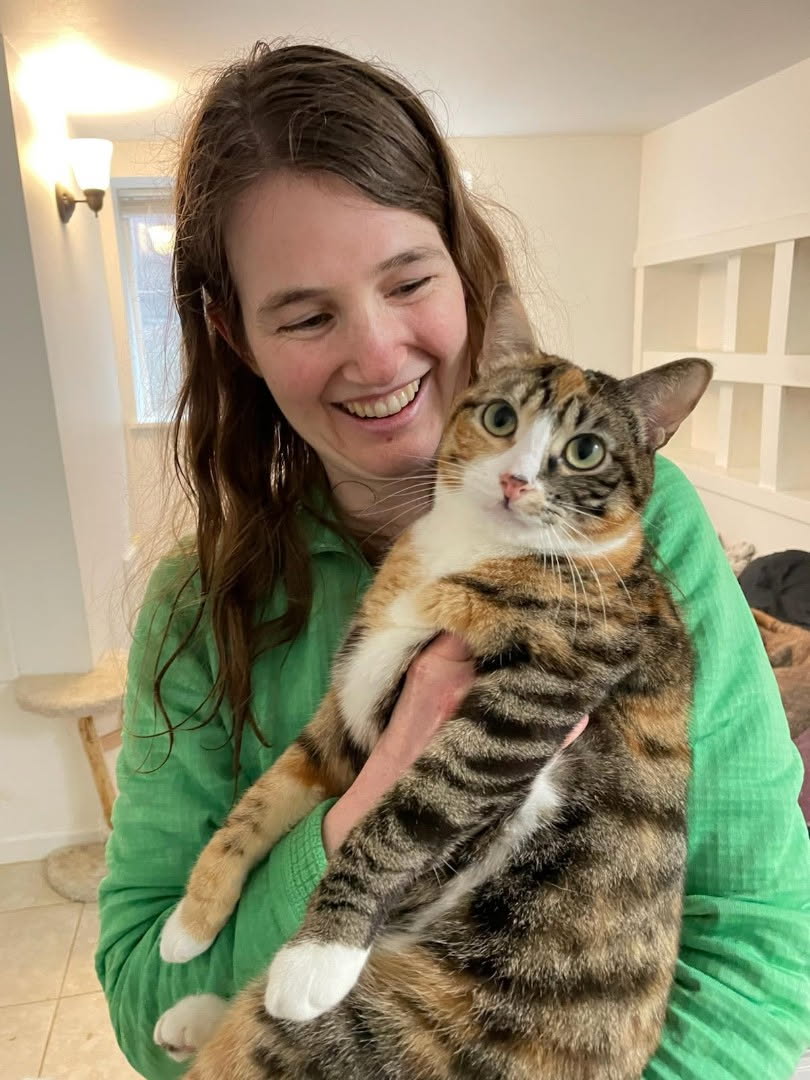 Kenzie holding a wide-eyed tabby rescue cat